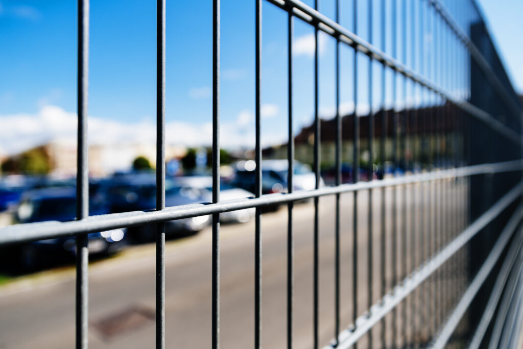 L’attribut alt de cette image est vide, son nom de fichier est close-up-metal-grille-fence-car-parking-security-concept-1024x684.jpg.